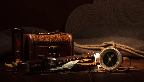 Old compass, treasure chest, hourglass, knife, money on  dark background. — Stock Photo, Image