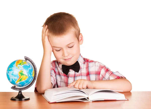 Söta skolpojke läsa bok, globe isolerad på vit. — Stockfoto