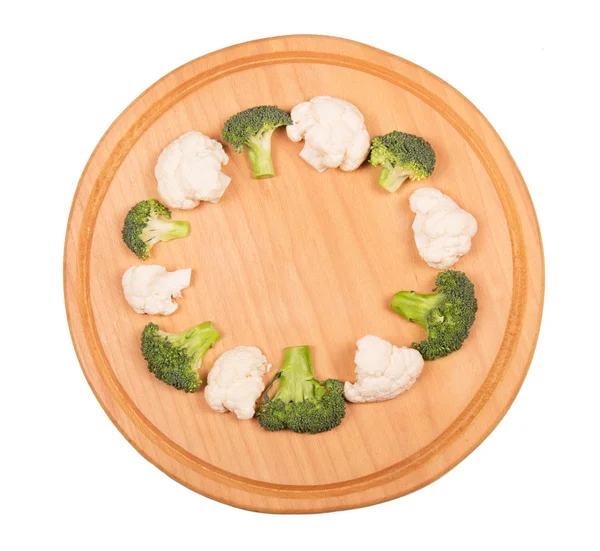 Brokoli, karnabahar ve beyaz arka plan üzerinde izole yuvarlak ahşap tahta. — Stok fotoğraf