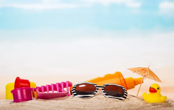 Zabawki dla dzieci, Okulary przeciwsłoneczne i krem w piasek z morza. — Zdjęcie stockowe