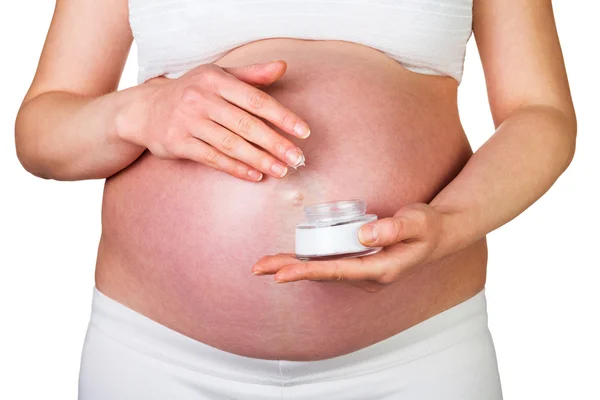 Mujer embarazada sosteniendo crema de tarro de extensiones aisladas en blanco . —  Fotos de Stock