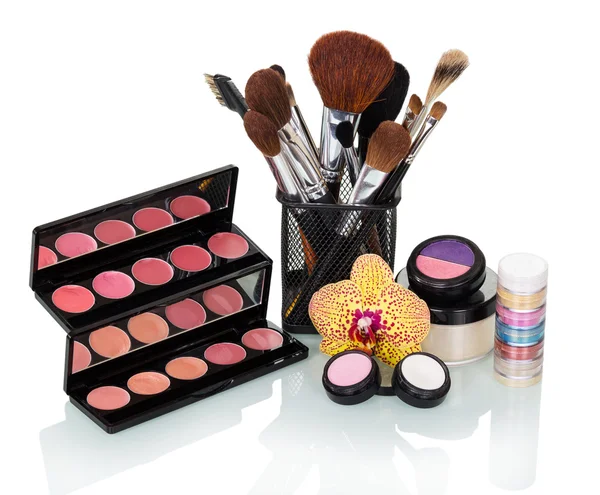 Cosmetic brush, eyeshadow, blush, lip gloss and orchid flower isolated. — Stock Photo, Image