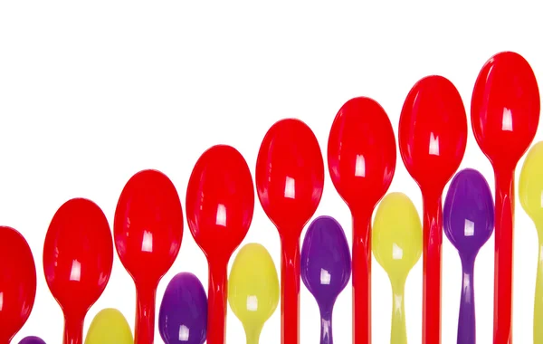 Lot of bright plastic spoons isolated on white background. — Stock Photo, Image