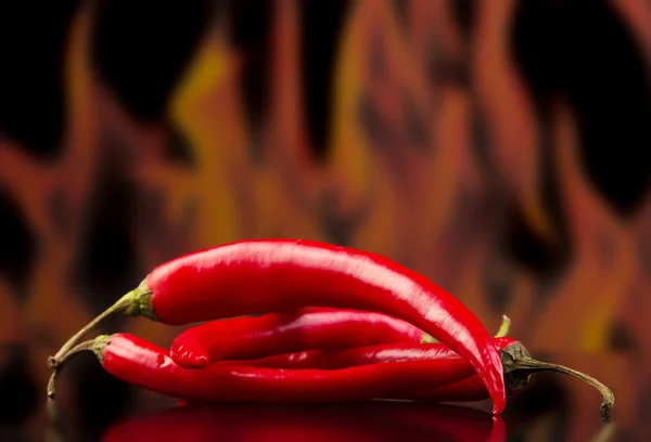 Pimienta picante roja en las llamas de fondo . — Foto de Stock