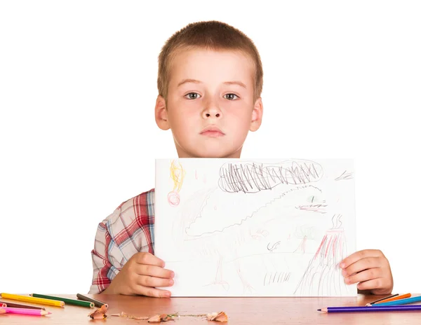 Lindo chico sentado en la mesa sosteniendo dibujo sobre fondo blanco . —  Fotos de Stock