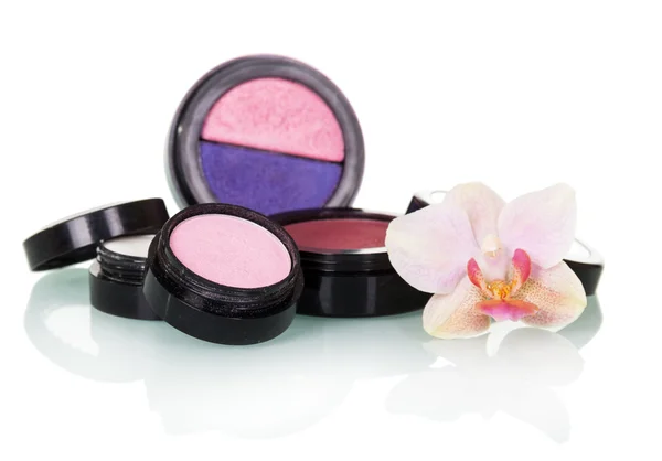 Professional Makeup: eyeshadow, blush and orchid flower isolated on white.