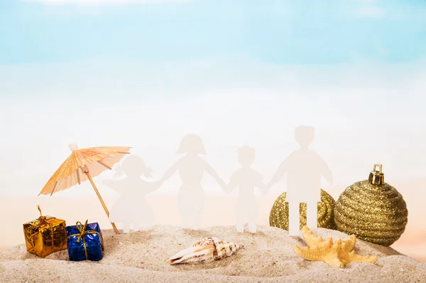 Family of paper, starfish, conch and holiday gifts in sand. — Stock Photo, Image