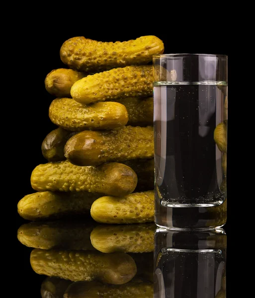 Üveg vodka és elszigetelt fekete háttér Ecetes uborka — Stock Fotó