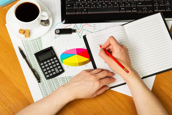 Mänskliga händer med penna, notebook, tangentbord, kalkylator, kaffe på skrivbordet. — Stockfoto