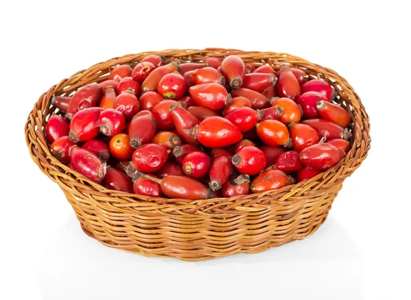 Rose hips in wicker basket isolated on white background. — Stock Photo, Image