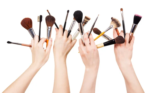 Mão das mulheres com escovas cosméticas para maquiagem isolada em branco  . — Fotografia de Stock