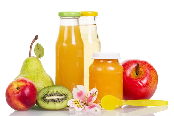 Bottles juice and jar pureed fruit, spoon, orchid flower. — Stock Photo, Image