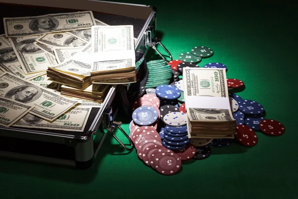 Open case with dollars and chips on  green cloth background — Stock Photo, Image