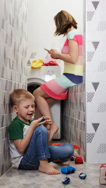 어린이들은 물질에 위험이 아이들은 어머니가 통화를 하면서 정신이 설거지용 캡슐을 — 스톡 사진
