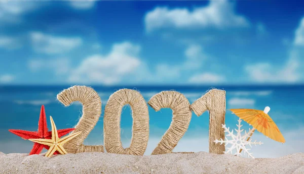暑い国で新年を祝うというコンセプト 砂浜の明るい日に雪の下の砂と雪の結晶の碑文2021 — ストック写真
