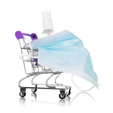 Güvenli alışveriş konsepti. Maske takan alışveriş arabası ve beyaz arka planda izole edilmiş dezenfektan.