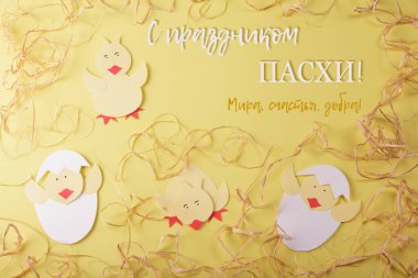 Ortodoks Paskalyası. Üst Manzara. Kağıt tavukların nazik bahar kompozisyonu ve Rusça yazıtlar