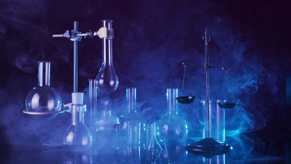 Chemical laboratory. Various test tubes and flasks, laboratory equipment in smoke with blue backlight