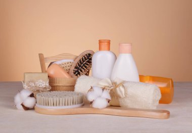 SPA ev kullanımı için ayarlandı. Bej arka planda vücut fırçası, kokulu sabunlar ve cilt bakım ürünleri