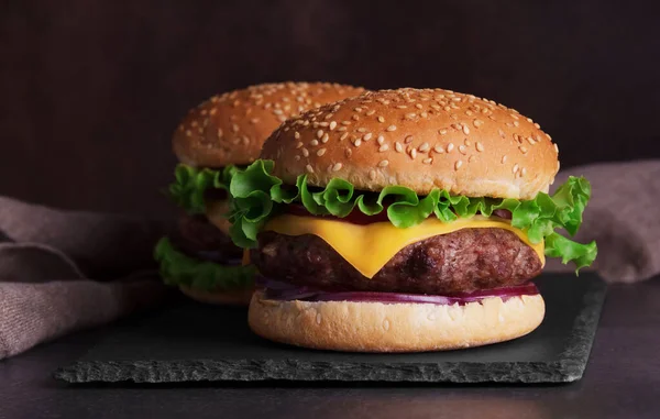 Zwei Hamburger Vor Dunklem Hintergrund Auf Einem Schieferteller — Stockfoto