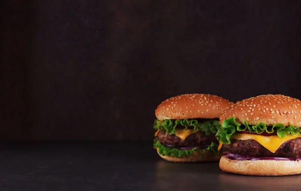 Twee Hamburgers Een Donkere Achtergrond Met Een Lege Plek Voor Stockfoto