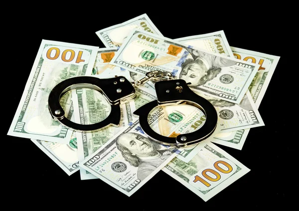 Handcuffs on dollar bills — Stock Photo, Image