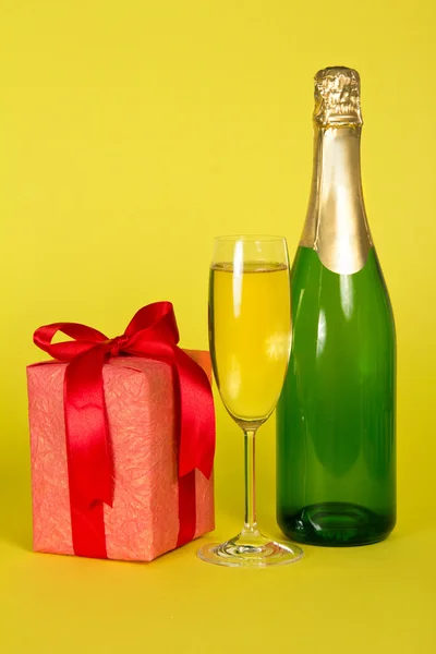 Шампанське зі склом і подарунком — стокове фото