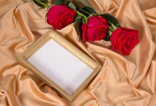 Roses in a and a frame on a cloth — Stock Photo, Image