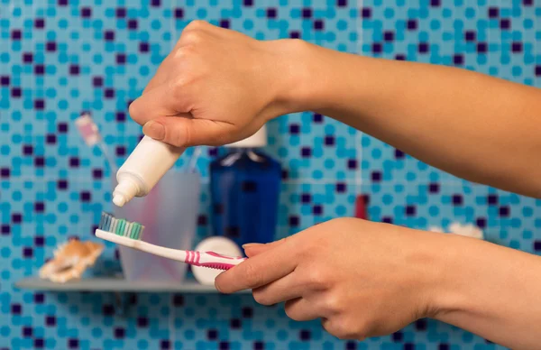 Manos con cepillo de dientes sobre fondo de estante —  Fotos de Stock