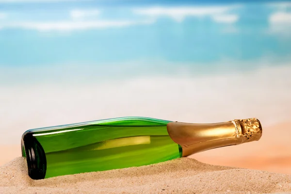Láhev šampaňského na písku — Stock fotografie
