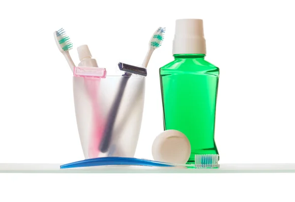 Toothpaste and toothbrushes on shelf — Stock Photo, Image