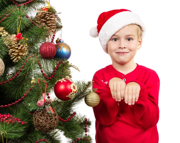 Junge als Weihnachtsmann verkleidet in der Nähe des Weihnachtsbaums — Stockfoto