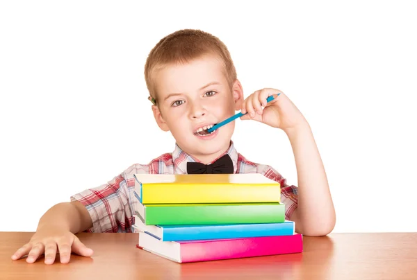 Niño detrás de escritorio con pila de libros de texto —  Fotos de Stock