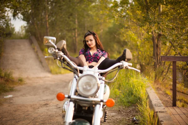 Piękna dziewczyna na motorze na zachodzie słońca. — Zdjęcie stockowe