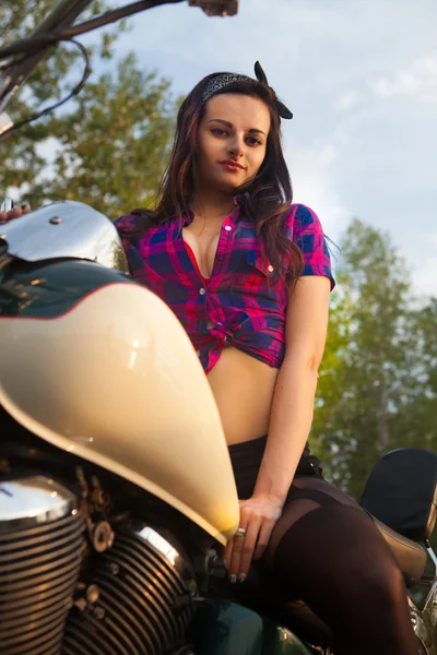 Beautiful girl on a motorcycle at sunset. — Stock Photo, Image