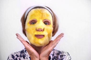 Güzel bir kadının yüzünde kömür ve oksijen temizleyici ürünler içeren baloncuk yüzlü maske. 50 'li yaşlarda, maske takan, cilt bakımlı olgun bir kadın..