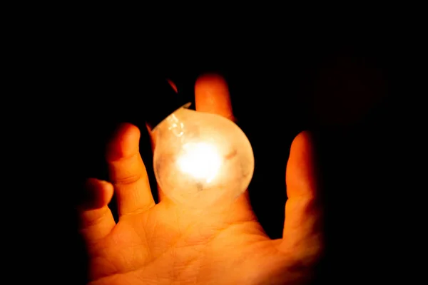 Mão Homem Tentando Segurar Uma Lâmpada Isolada Fundo Escuro — Fotografia de Stock
