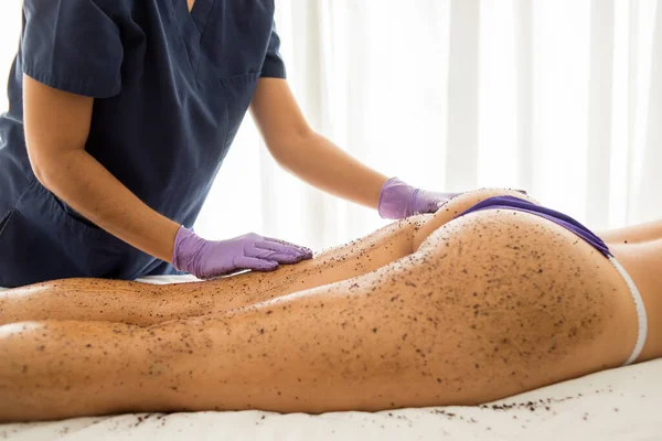 A woman getting a whole-body relaxing scrub massage done in a spa