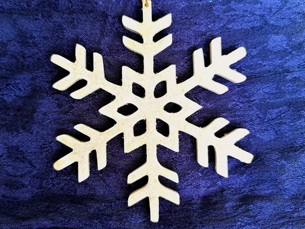 Tiro Close Ornamento Floco Neve Madeira Uma Superfície Azul — Fotografia de Stock