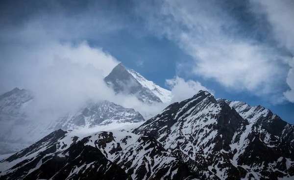 一幅覆盖着白雪的山脉的壮观风景 云彩覆盖着峰顶 — 图库照片