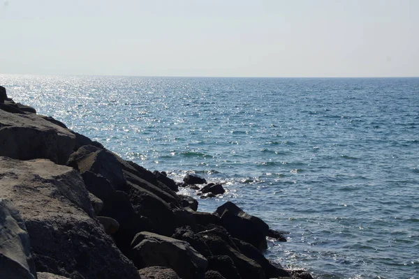 晴れた日に岩の多い海岸を襲う波の眺め — ストック写真