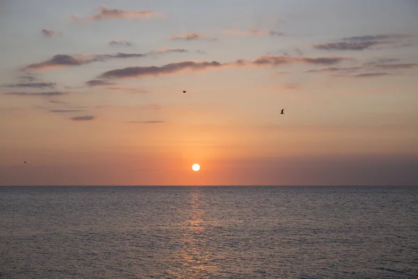 Hermosa Puesta Sol Mar Agua Tranquila Cielo Tiene Colores Anaranjados —  Fotos de Stock