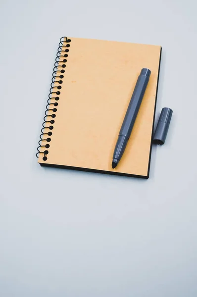 Plano Vertical Cuaderno Marcador Sobre Una Superficie Azul — Foto de Stock