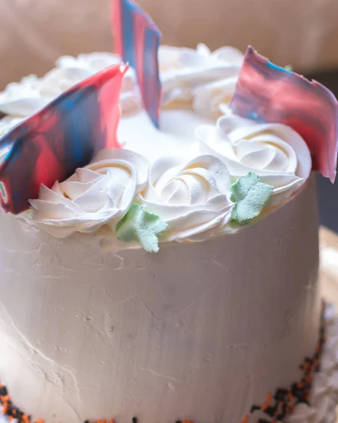バラと赤と青の装飾が施された新鮮なおいしいケーキの垂直クローズアップショット — ストック写真