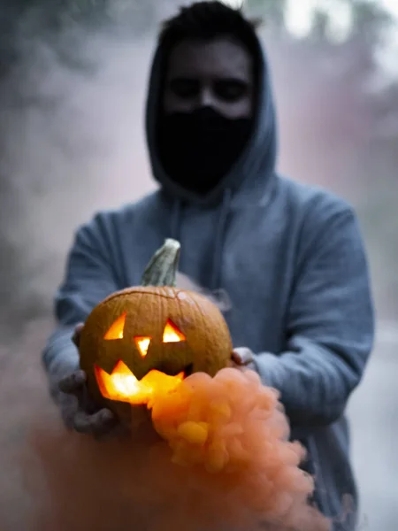 Una Toma Espeluznante Tipo Europeo Sosteniendo Una Calabaza Halloween Humeante —  Fotos de Stock