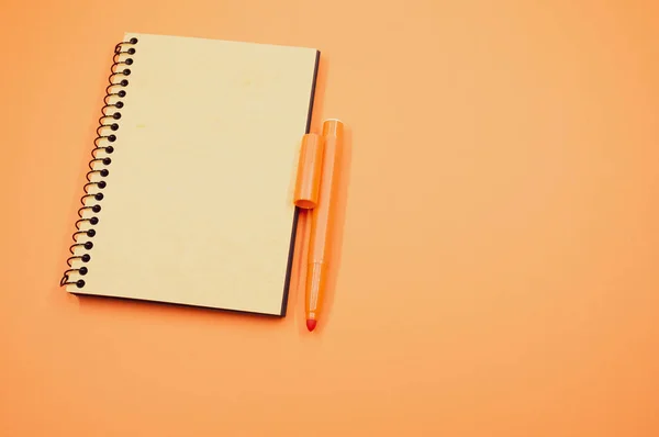 Ujęcie Pod Wysokim Kątem Notebooka Pomarańczowego Markera Pomarańczowej Powierzchni — Zdjęcie stockowe