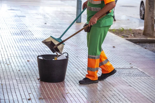 A worker sweeping and cleaning the streets of the city