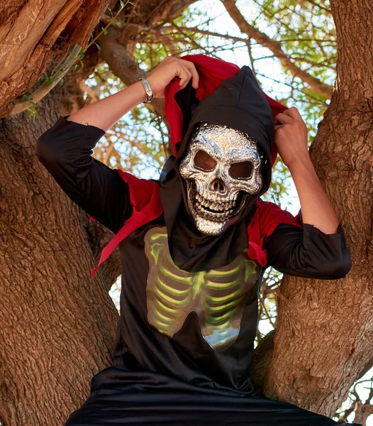 木の上に座っているハロウィンの衣装を着ている人の垂直クローズアップショット — ストック写真