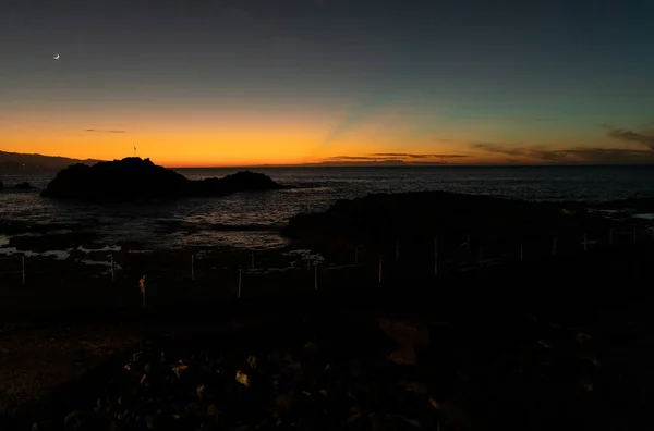 美丽的金色落日掠过平静的海景 这里有岩石般的海岸线 — 图库照片