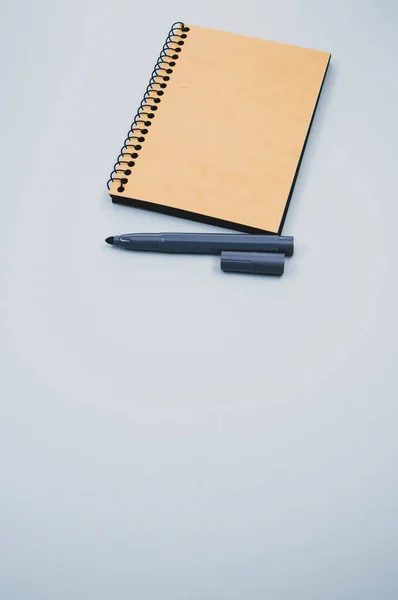 Plano Vertical Cuaderno Marcador Sobre Una Superficie Azul — Foto de Stock